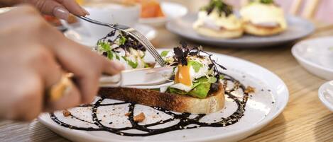 A person serving food on a white plate with a fork.