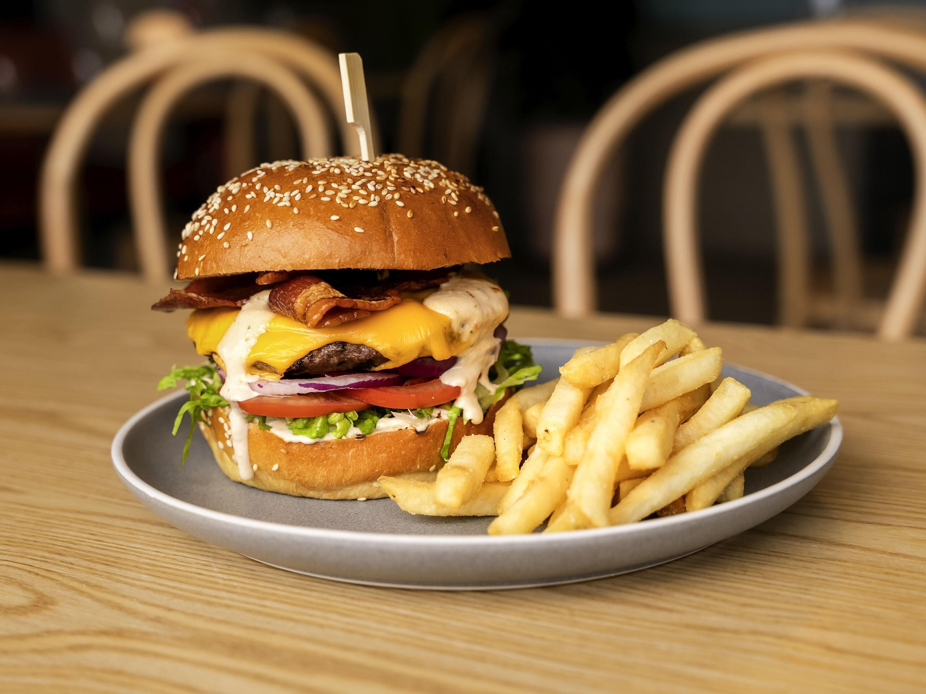 A plate with a burger and fries on a table.