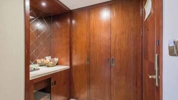A wooden wardrobe with a mirror and a shelf with a basket.