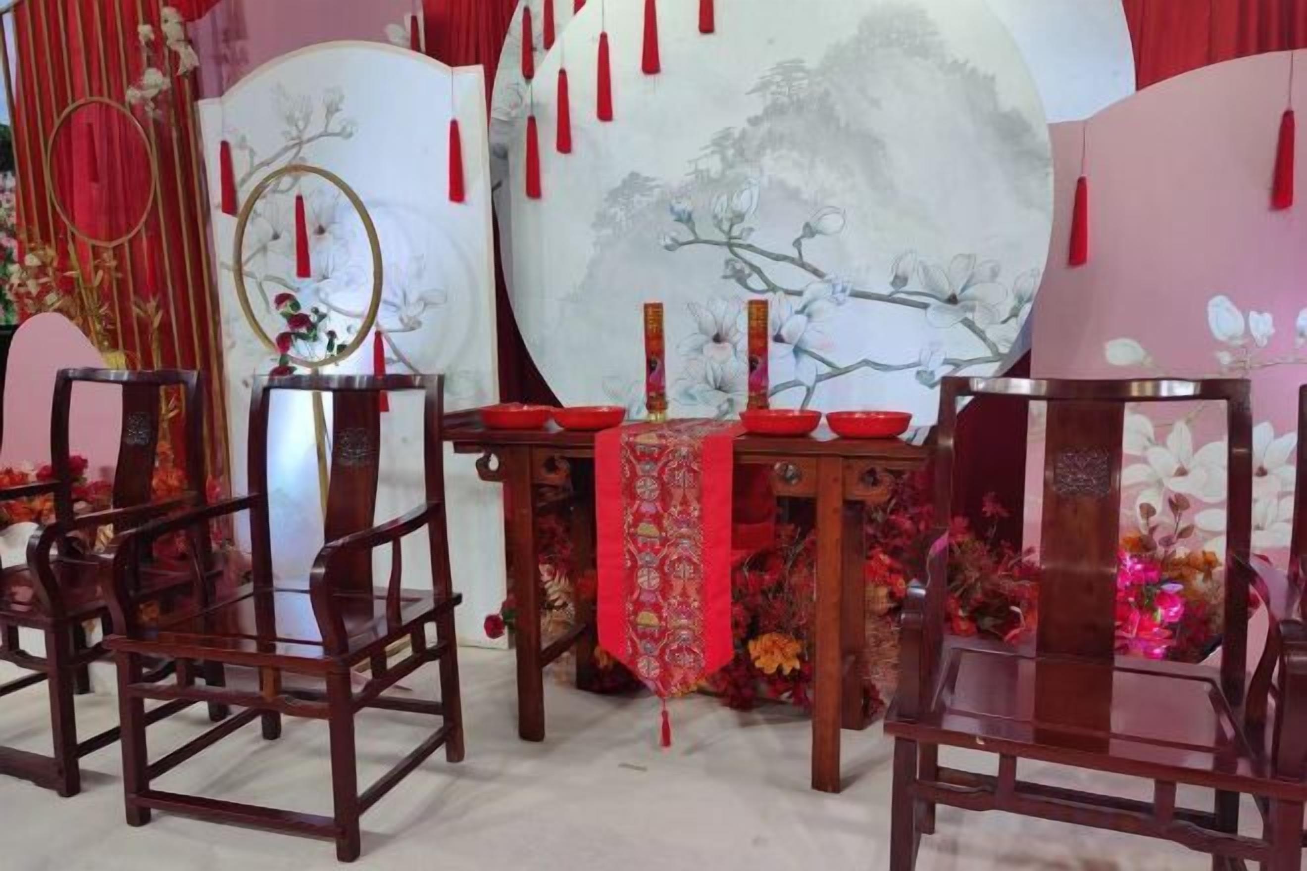 A traditional Chinese setting with a table, chairs, and decorative elements.
