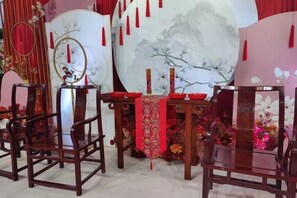 A traditional Chinese setting with a table, chairs, and decorative elements. - Jun'an International Hotel (Cenxi)