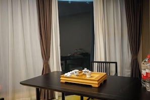 A dining table with a tray of teaware and a bottle of water. - Jun'an International Hotel (Cenxi)