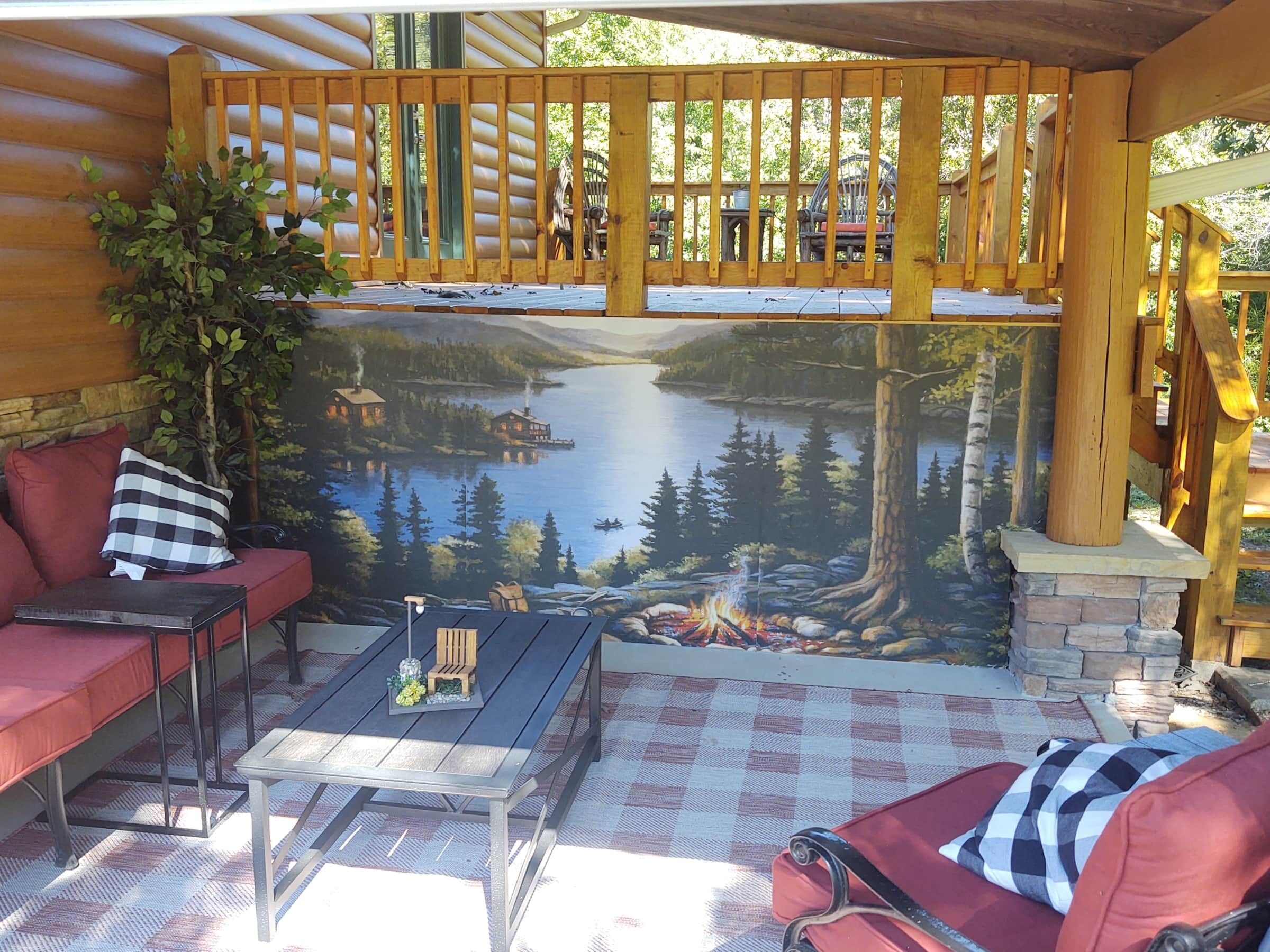 Un espace extérieur accueillant, aménagé avec des sièges confortables et offrant une vue sur un lac et une forêt.