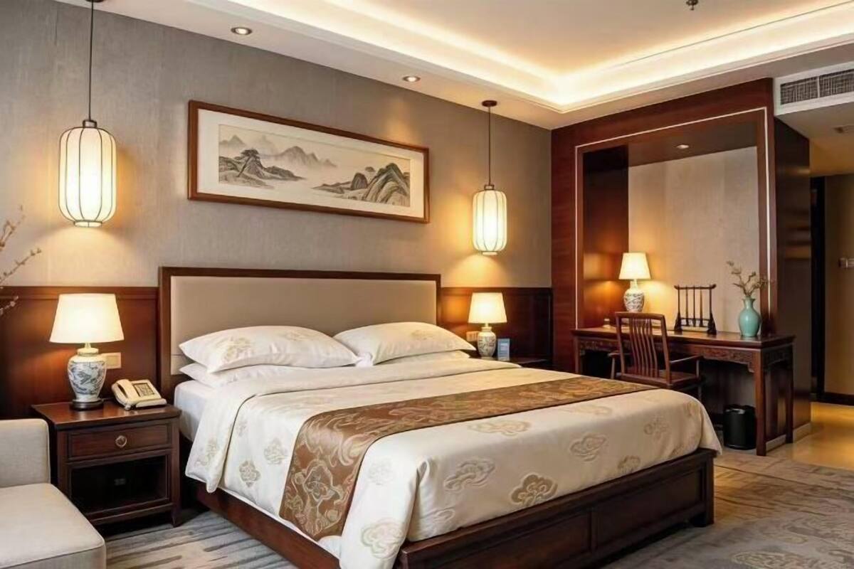 Ein Hotelzimmer mit Bett, Nachttischen, Lampen, Schreibtisch und Stuhl.