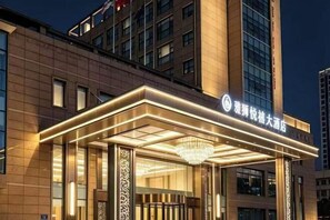A hotel entrance with a modern design, featuring a prominent entrance canopy and a large chandelier. - Wuxi Yuexi Grand Hotel (Huishan Wanda) (Wuxi)