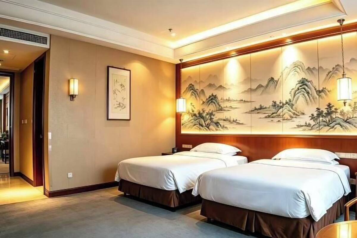 Ein Hotelzimmer mit zwei Betten, einem großen Wandbild und einem hölzernen Kopfteil.