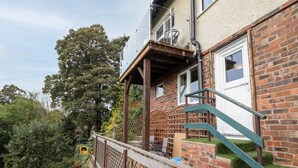 Un edificio residencial con fachada de ladrillo, una escalera de madera y un balcón.