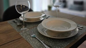 A dining table set with plates, a wine glass, and a fork. - Charming 1-bed Apartment in Zagreb (Zagreb)