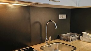 A modern kitchen with a stainless steel sink, a gas stove, and wooden countertops. - Charming 1-bed Apartment in Zagreb (Zagreb)