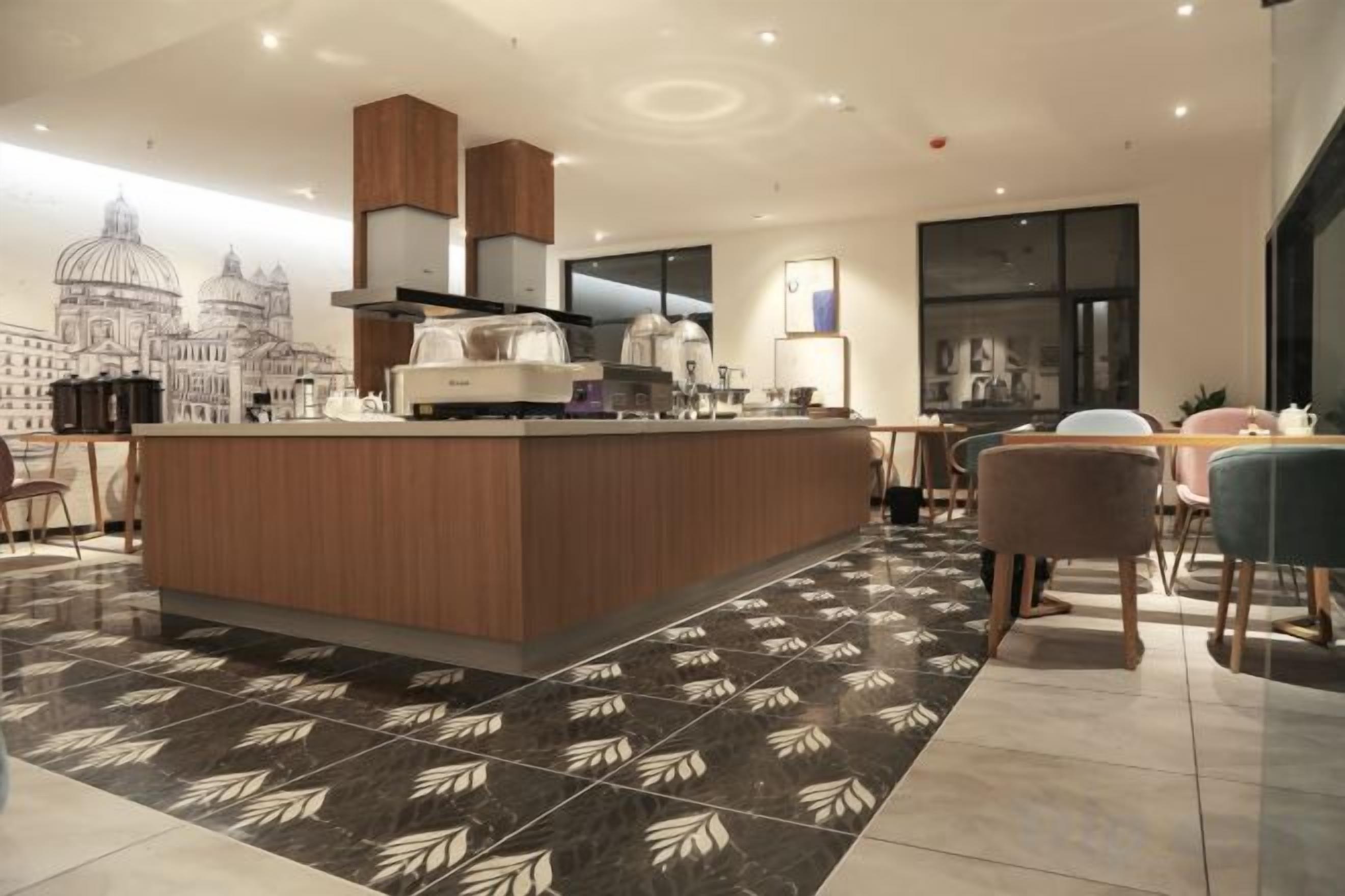 Una cocina moderna con una isla central, un comedor con mesa y sillas, y un amplio ventanal con vista a la ciudad.