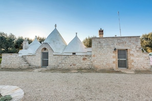 A stone building with conical roofs and a small stone tower.