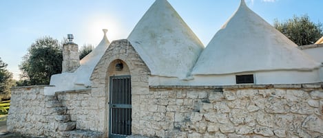 A stone building with a central arched entrance and conical roofs.