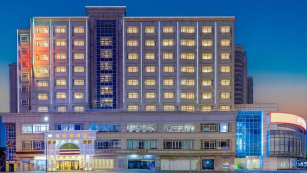 Ein mehrstöckiges Hotel mit einem markanten Eingang und mehreren Geschäften im Erdgeschoss.