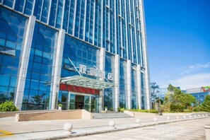 A modern building with a glass facade and a clear sky. - Guanlan Hotel (Ningbo)