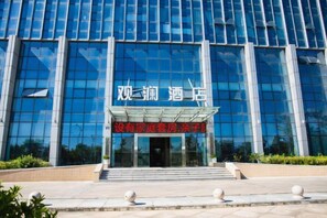 A modern building with a glass facade and a sign indicating a hotel.