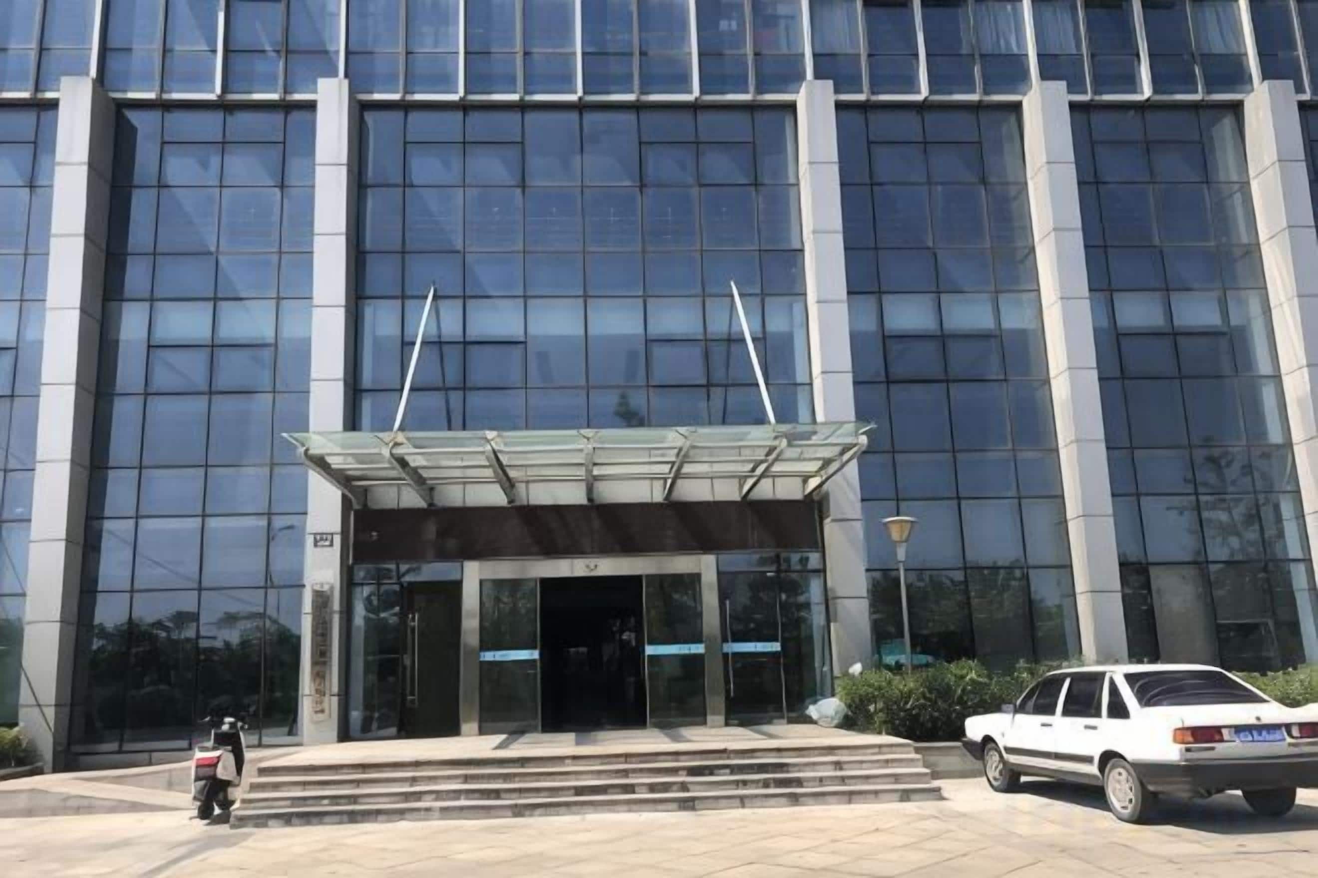 A modern building with a glass facade and a covered entrance.