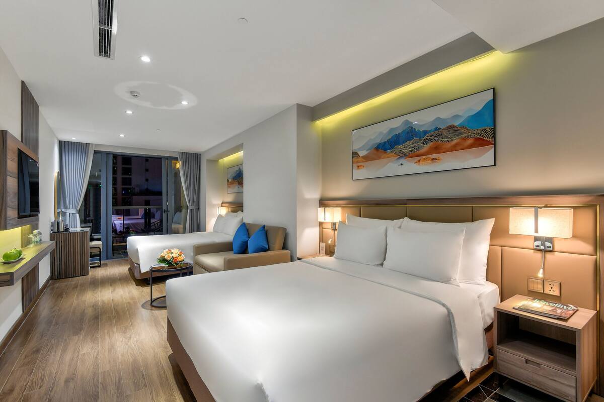 Una habitación de hotel moderna con una cama grande, un sofá, un escritorio y un comedor.