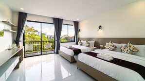 Habitación de hotel moderna con dos camas, un balcón, un escritorio y vista a la ciudad.