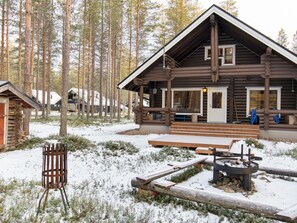 A log cabin with a porch, a fire pit, and a bench. - Kirnutie 3 by Interhome (Pelkosenniemi)