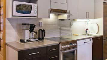 A modern kitchen with a microwave, coffee maker, and dishwasher.