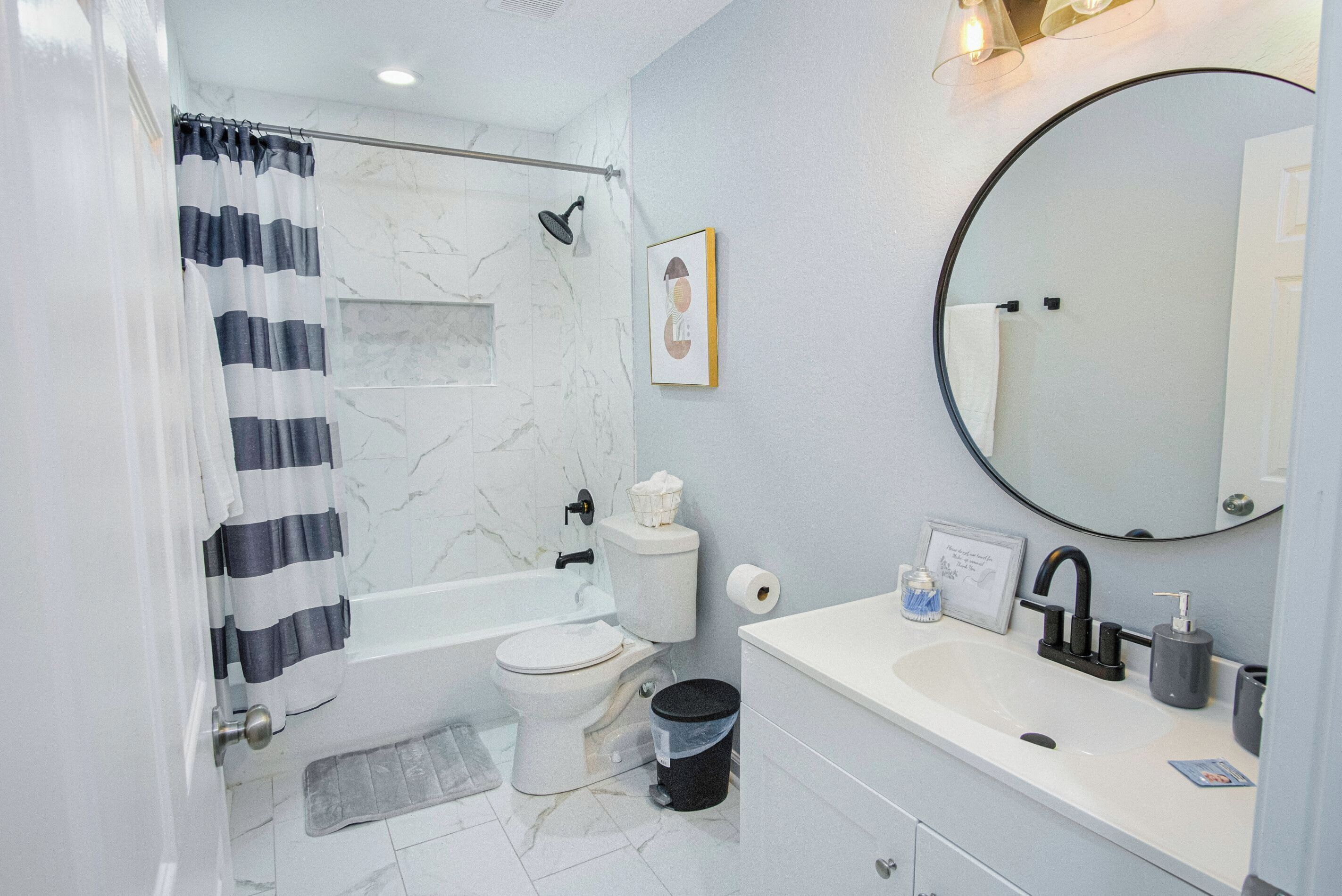 A modern bathroom with a bathtub, toilet, and sink.