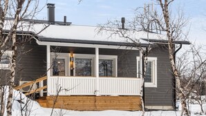 A two-story house with a covered porch and a chimney. - Willa kiiruna by Interhome (Enontekiö)