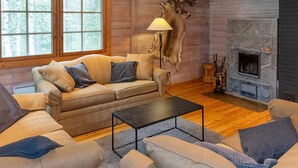 A cozy living room with a sofa set, a coffee table, and a fireplace.