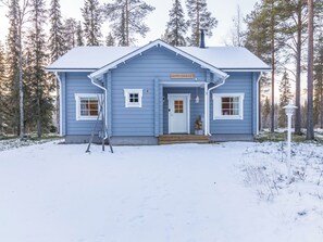 A two-story building with a blue exterior, a front porch, and a sign that reads 'OUTA-KURSU'.