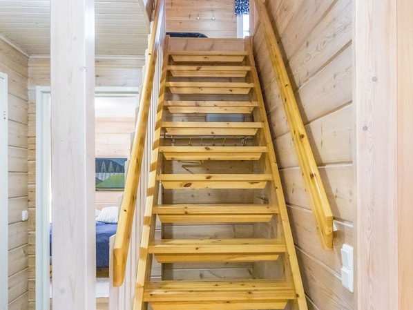 A wooden interior staircase with a handrail, leading to an upper level. - Outa-kursu by Interhome (Pelkosenniemi)