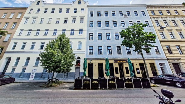 Ein mehrstöckiges Gebäude mit einer Café-Bar im Erdgeschoss.