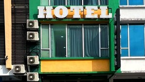 Un hotel con un letrero llamativo que dice "HOTEL" en letras rojas y blancas.
