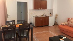 Um espaço compacto com área de jantar, kitchenette e sofá.