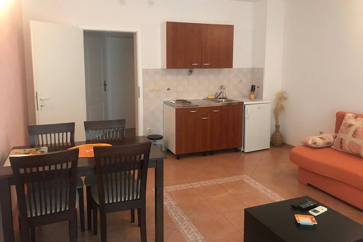 Un espace de vie compact comprenant un coin repas, une kitchenette et un canapé.