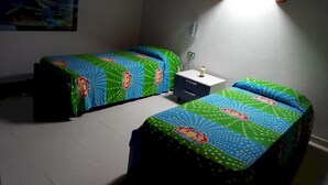 A room with two beds, a nightstand, a wall clock, and a painting. - San Lazzaro 81 Mansarda (Andora)