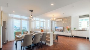 Un comedor moderno con una mesa grande, sillas y vistas a la ciudad a través de amplias ventanas.