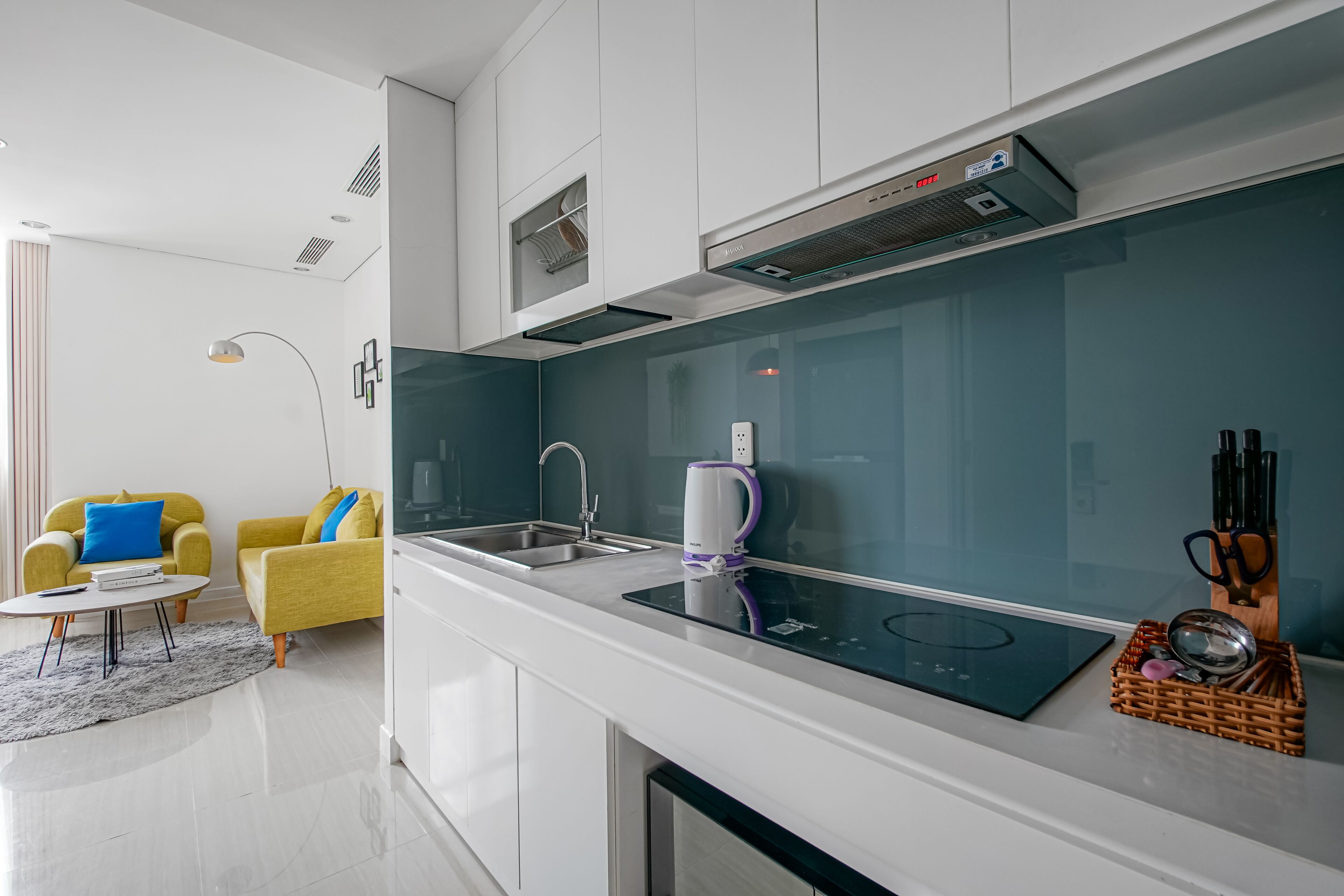 Eine moderne Küche mit Einbauherd, Spüle und Fenster zum Wohnbereich.