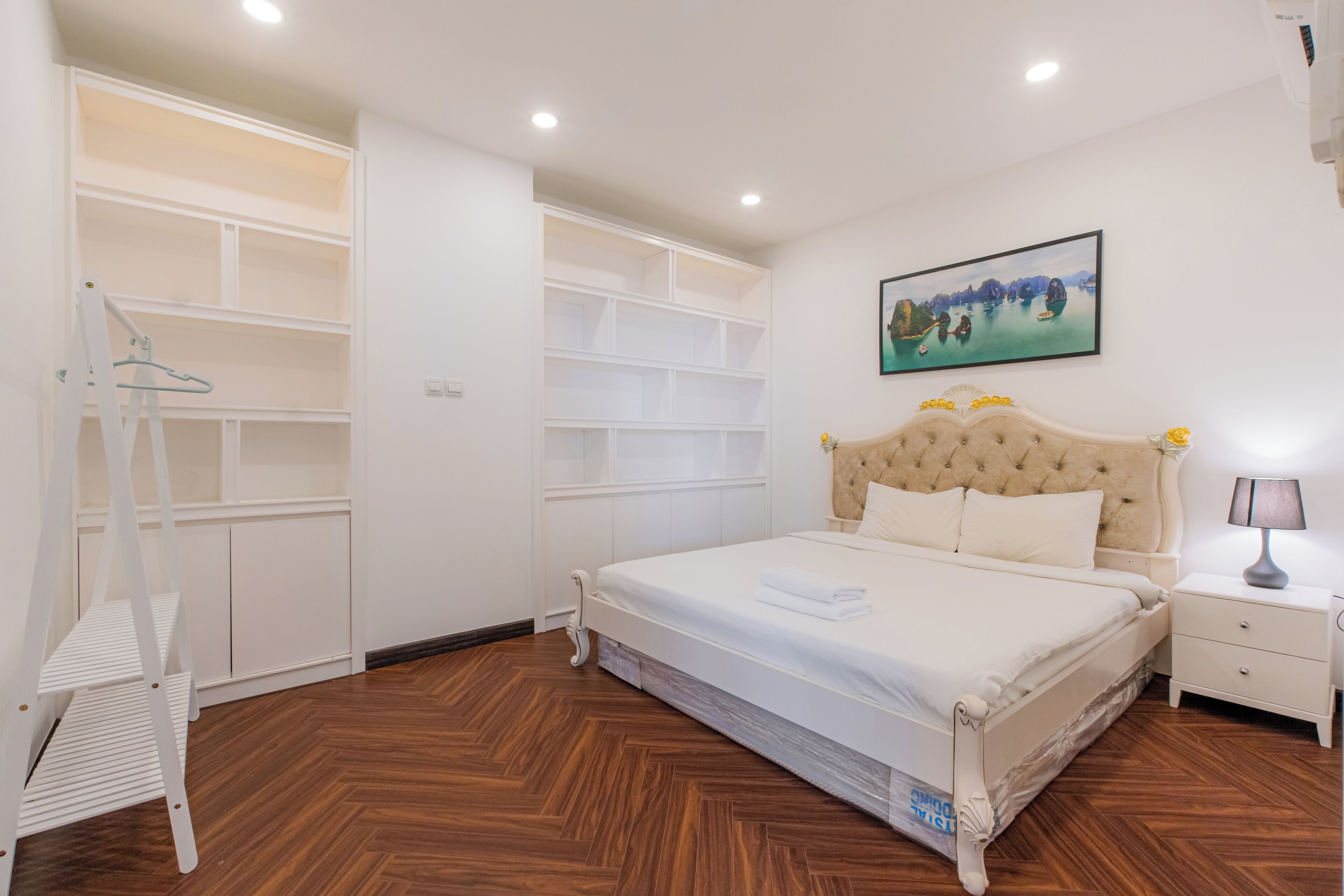 Une chambre avec un grand lit, des étagères intégrées, une échelle et une table de chevet.