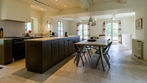 Una cocina amplia con una isla central, electrodomésticos modernos y abundante luz natural gracias a grandes ventanales.