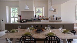 Una cocina amplia con una isla grande, electrodomésticos modernos y mucha luz natural.