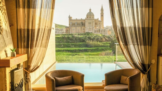 A room with a view of a large building and a pool. - Twilight Holiday Home (Għasri)