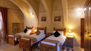 A room with two wooden beds, each with a nightstand and lamp, in a stone-walled room with arched ceilings. - Villeleynah Holiday Home (Gozo)