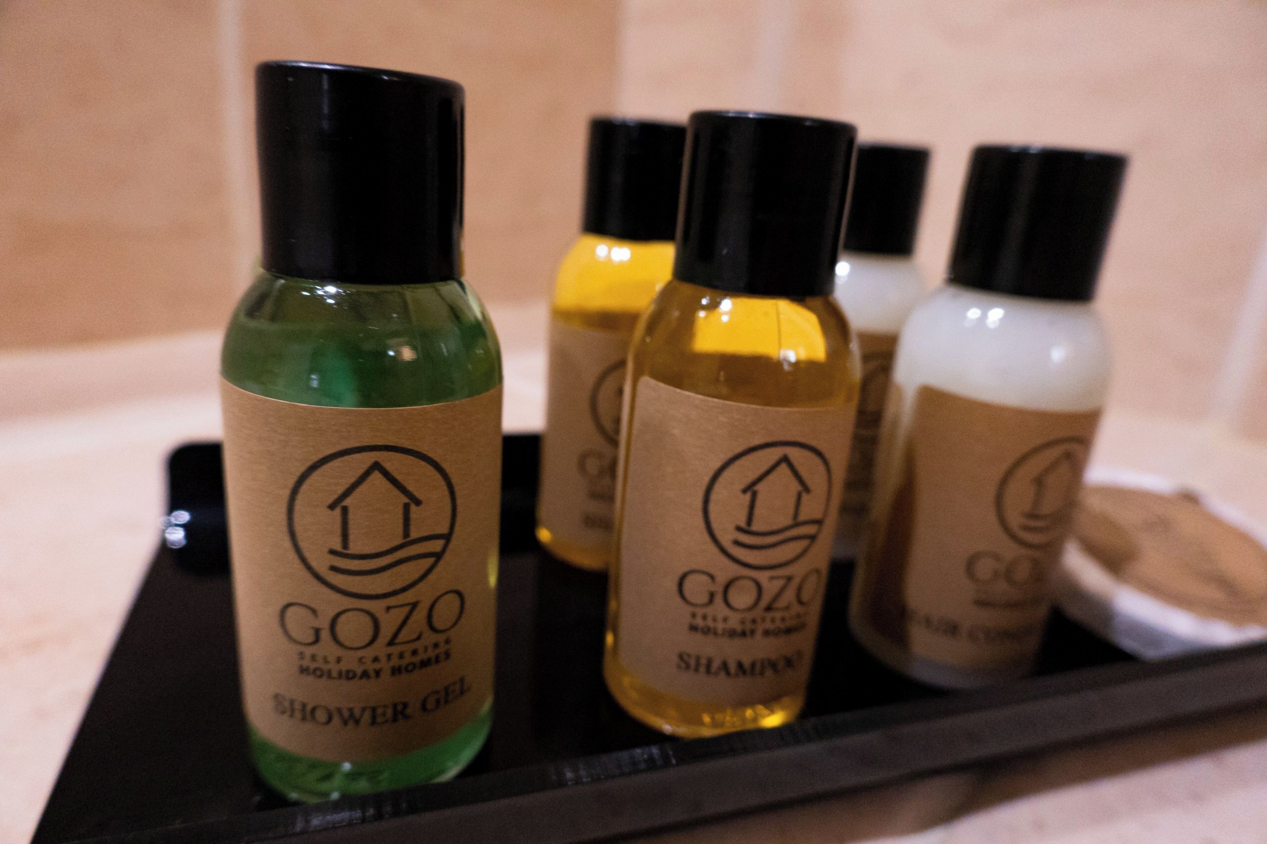 A tray with four bottles of Gozo self-care products.