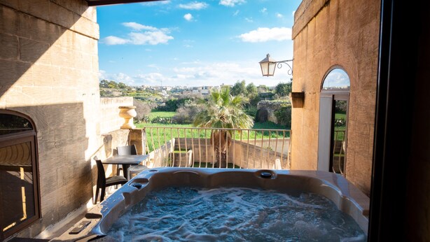 A hot tub with a view of a cityscape and greenery. - Centre Island Holiday Home (Ir-Rabat Għawdex)