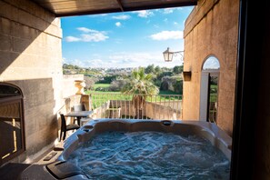 A hot tub with a view of a cityscape and greenery. - Centre Island Holiday Home (Ir-Rabat Għawdex)
