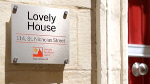 Señal que indica 'Lovely House' en el número 114 de la calle St. Nicholas Street, mostrando que forma parte de Valetta Boutique Living.