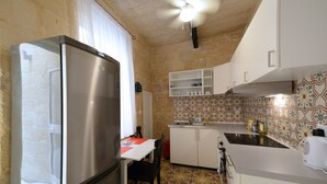 Una cocina compacta con refrigerador, una mesa de comedor con sillas y un salpicadero con diseño.