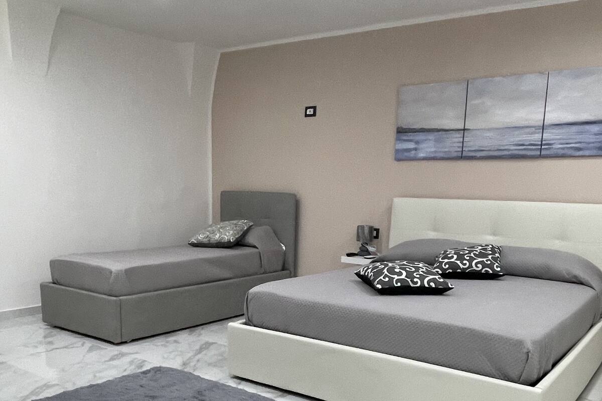 Ein modernes Schlafzimmer mit einem Bett, einem Sofa und einem Teppich.