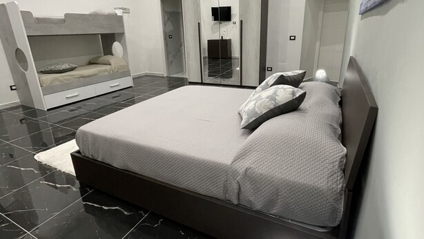 Un dormitorio moderno con una cama grande, un armario y un banco empotrado.