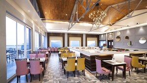 A modern hotel lobby with a high ceiling, large windows, and a central bar area. - WelcomHeritage Parv Vilas Resort & Spa (Solan)