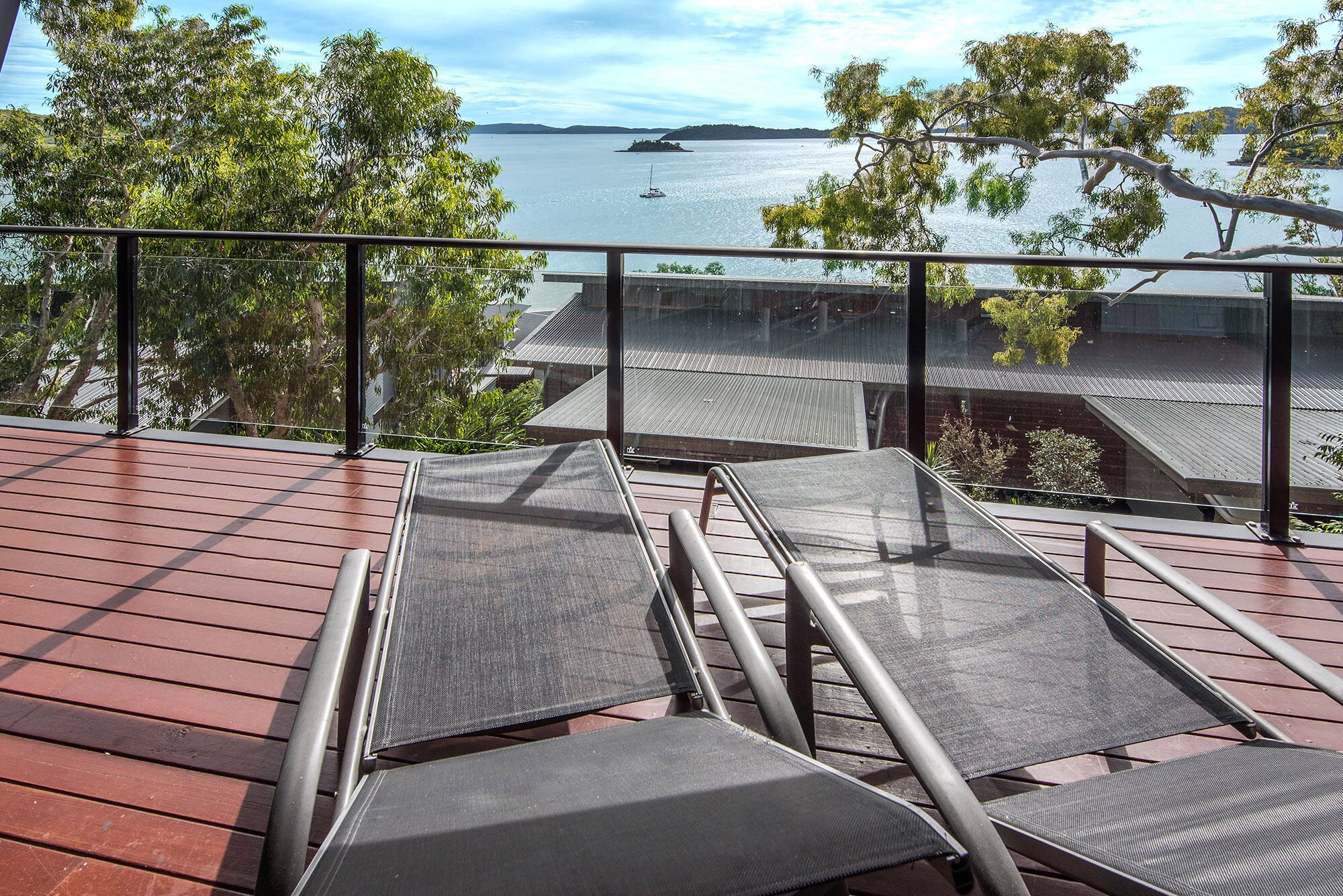 A deck with outdoor seating and a view of a body of water.